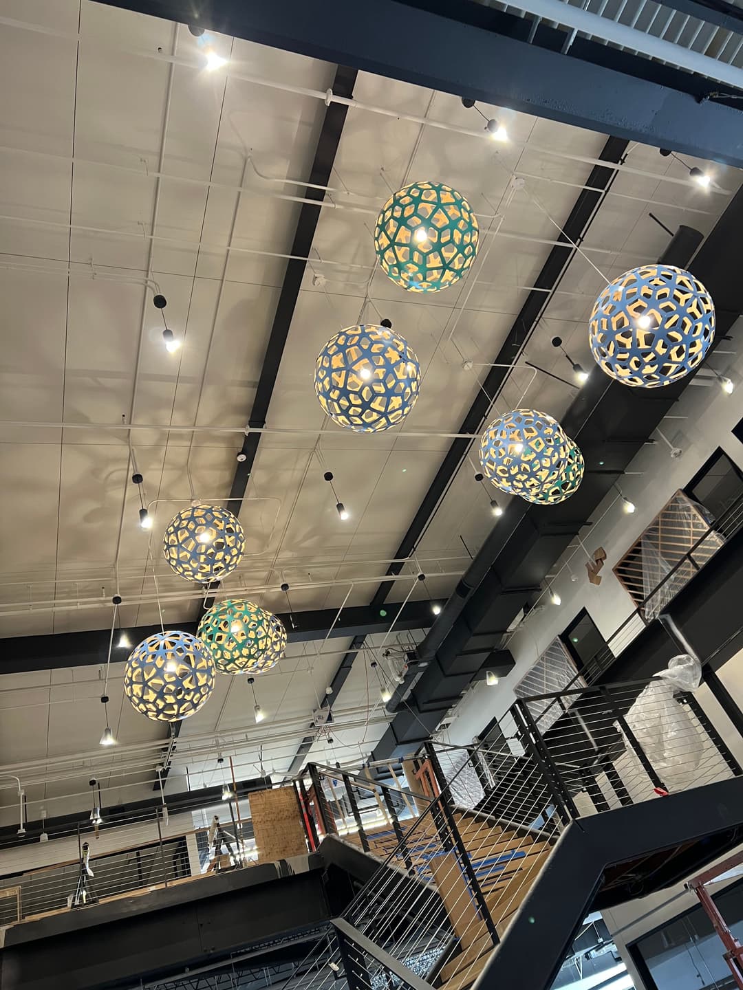 Colorful pendant lights hang from a modern ceiling in a stylish interior space.